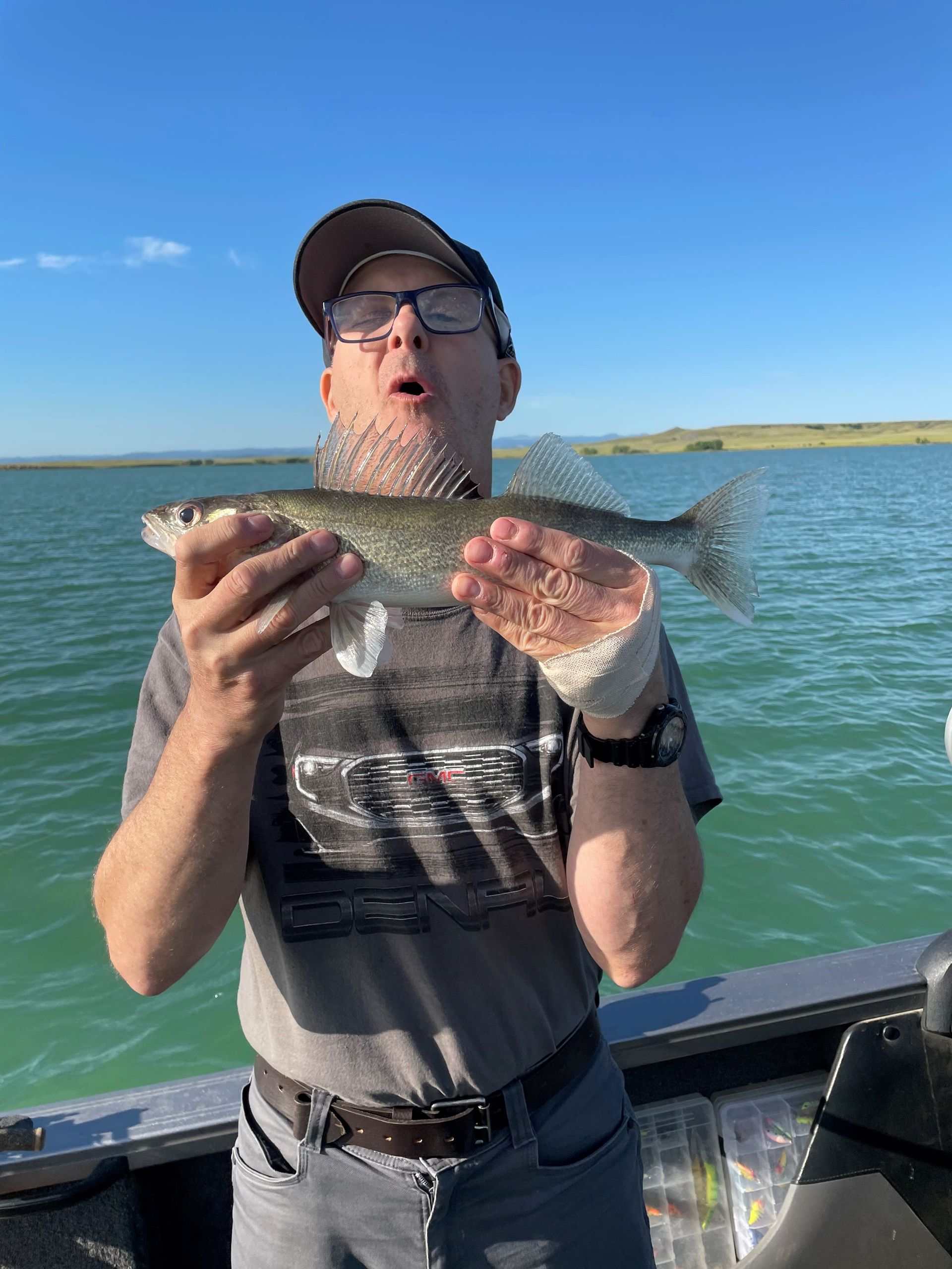 A man is holding a fish in his hands on a boat