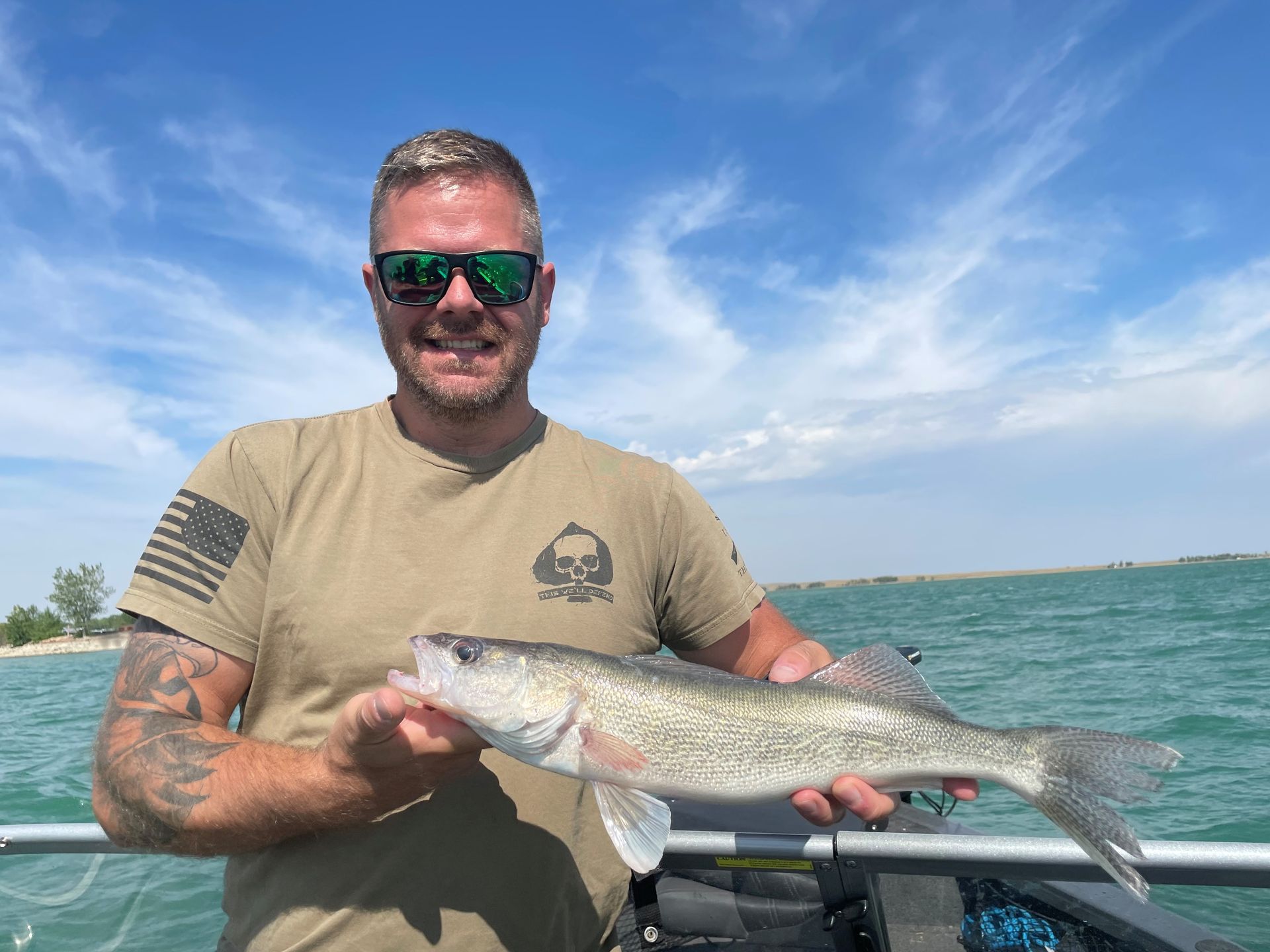 A man is holding a large fish on a boat