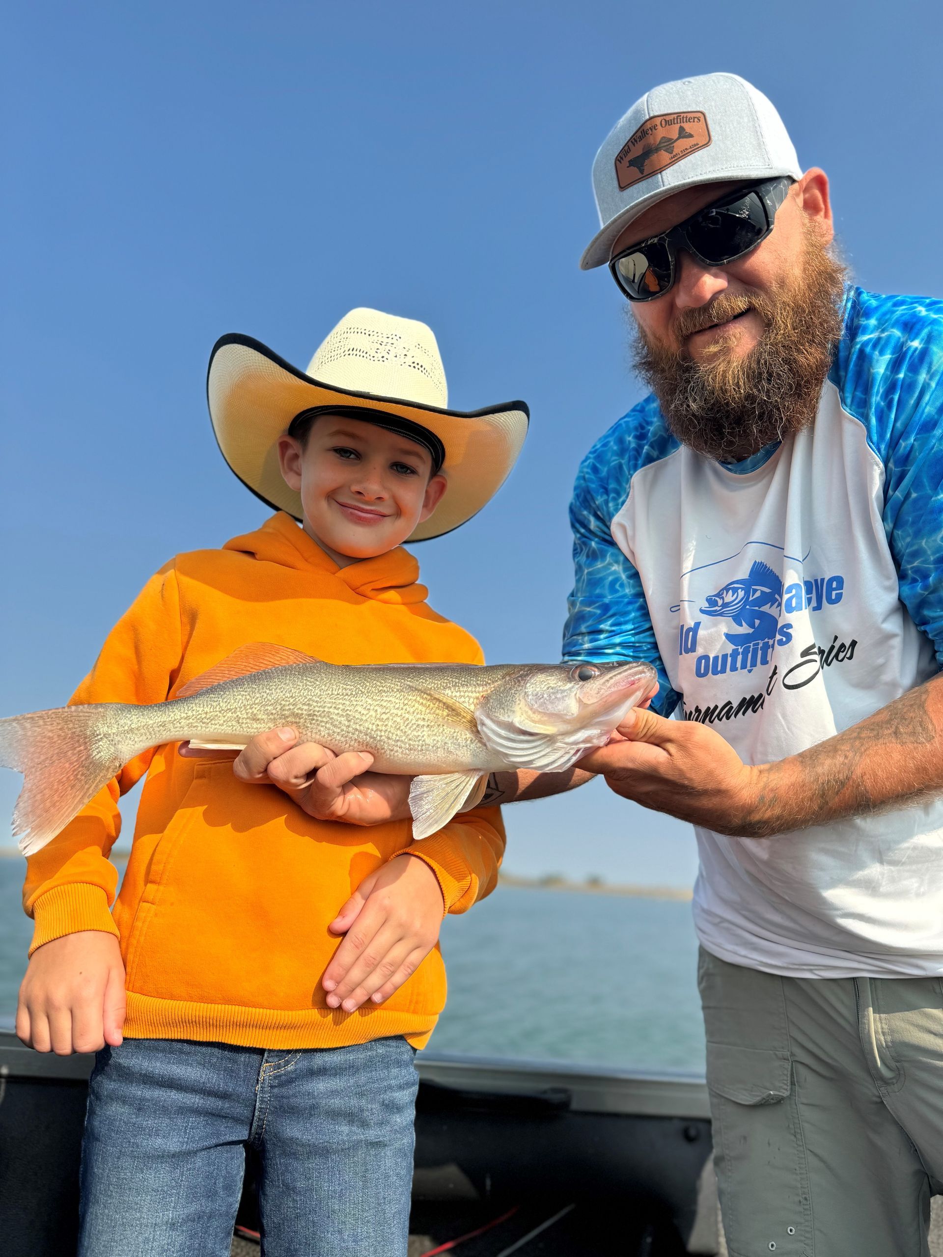 A man and a boy are holding a fish