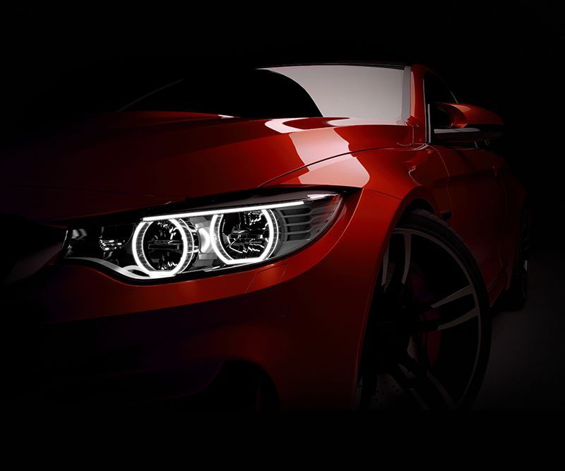 A close up of a red car 's headlights in the dark
