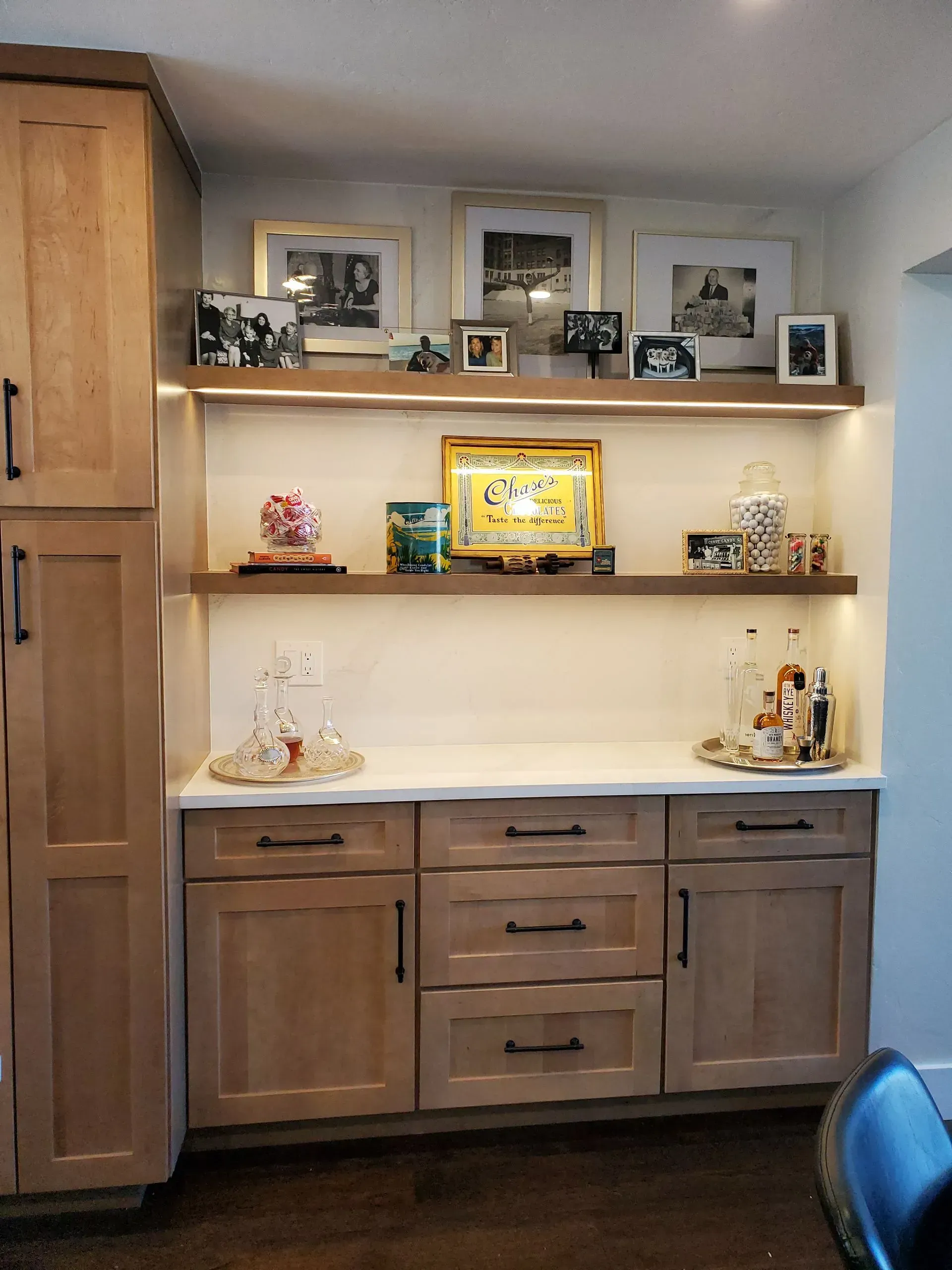 Built-in cabinet with floating shelves, illuminated with framed art and decor.