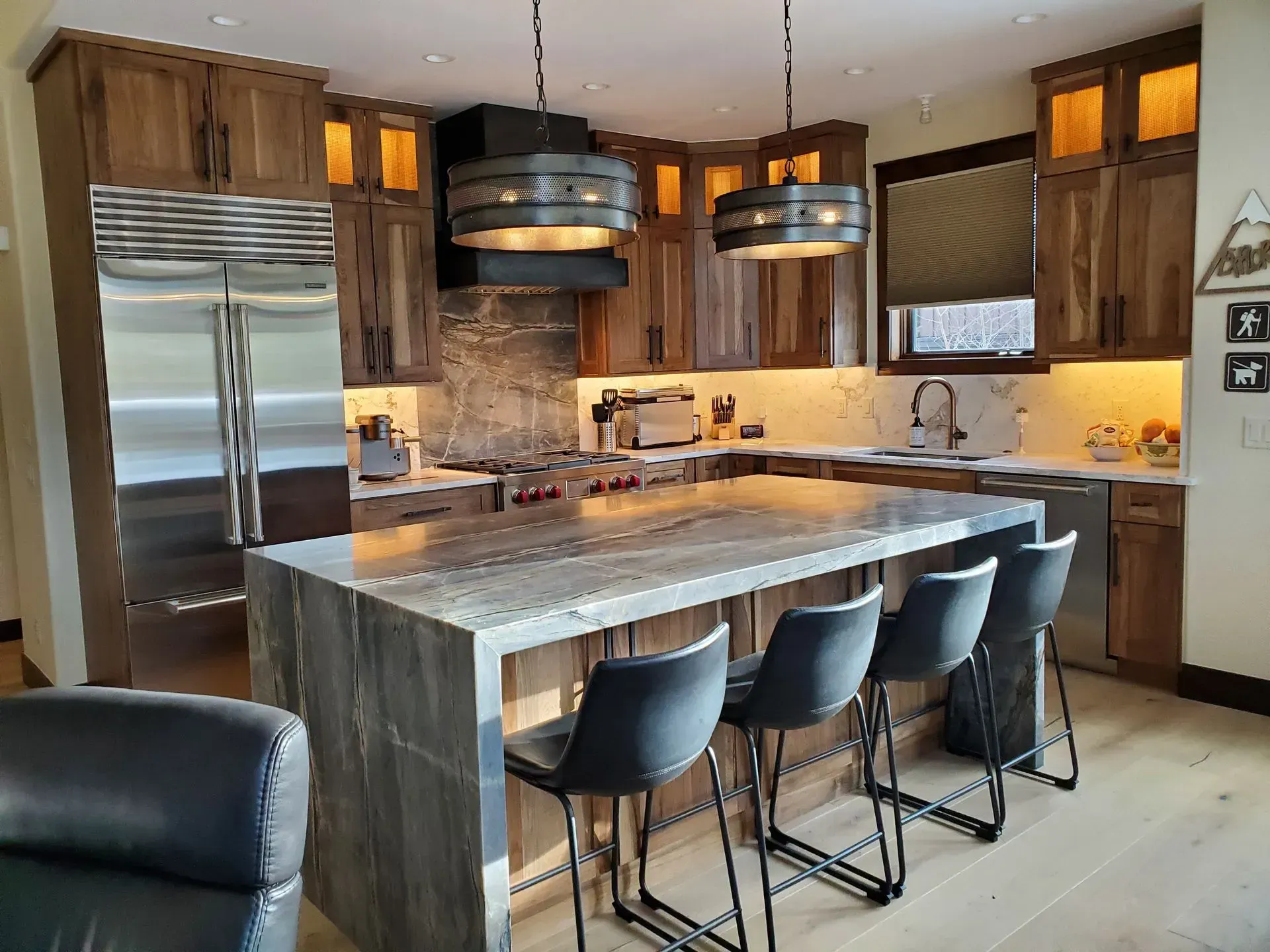 Modern kitchen with wood cabinets, stainless steel appliances, and a large island with bar stools.
