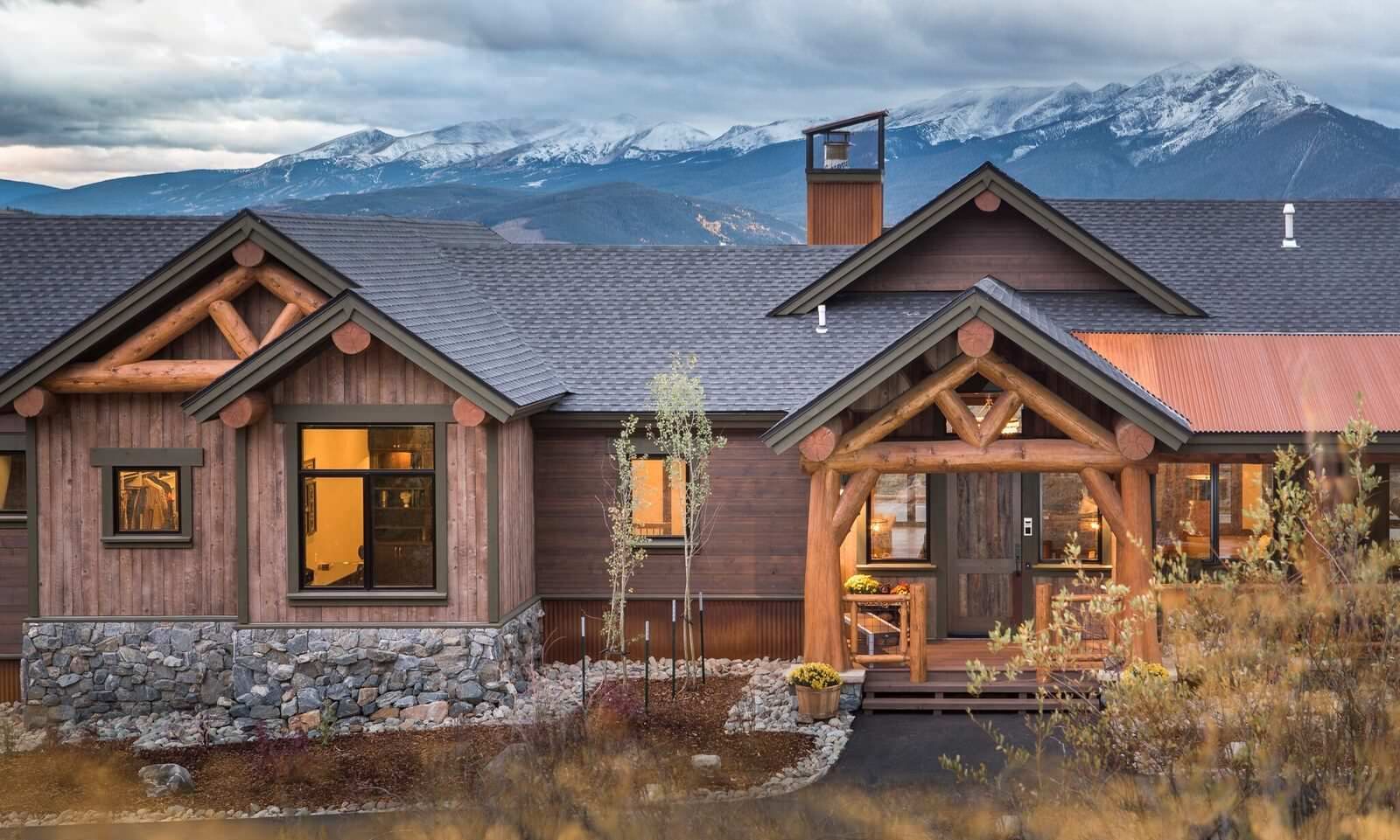 Rustic wooden cabin with mountain backdrop.