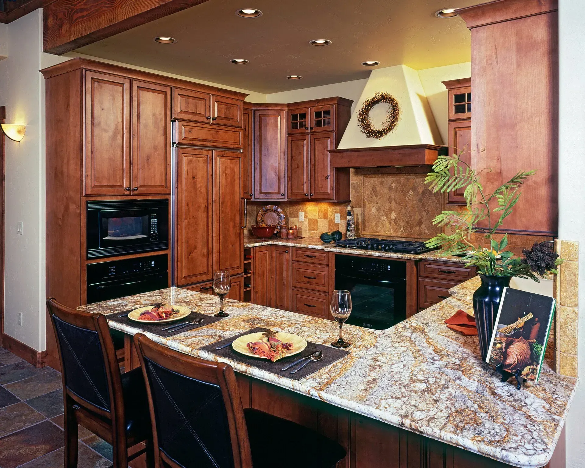 Kitchen with wood cabinets, granite countertops, and breakfast bar.