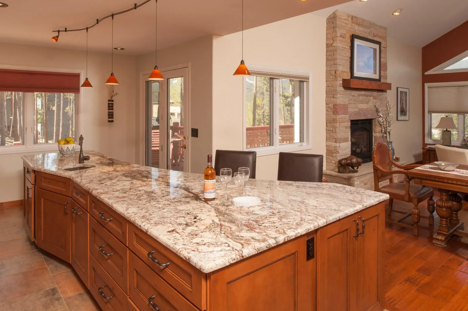 Large kitchen with granite island and brick fireplace.