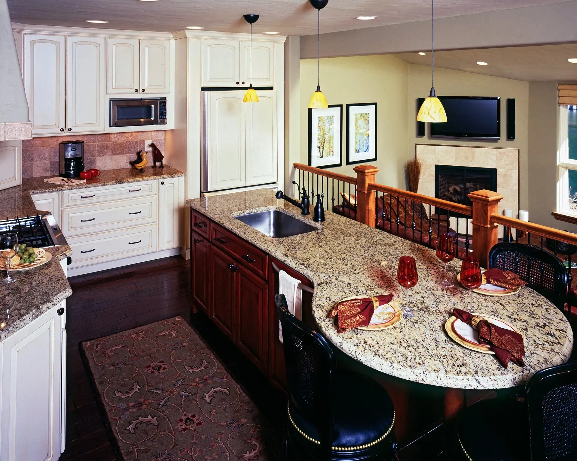 Kitchen with granite countertops, wood cabinets, and seating area.