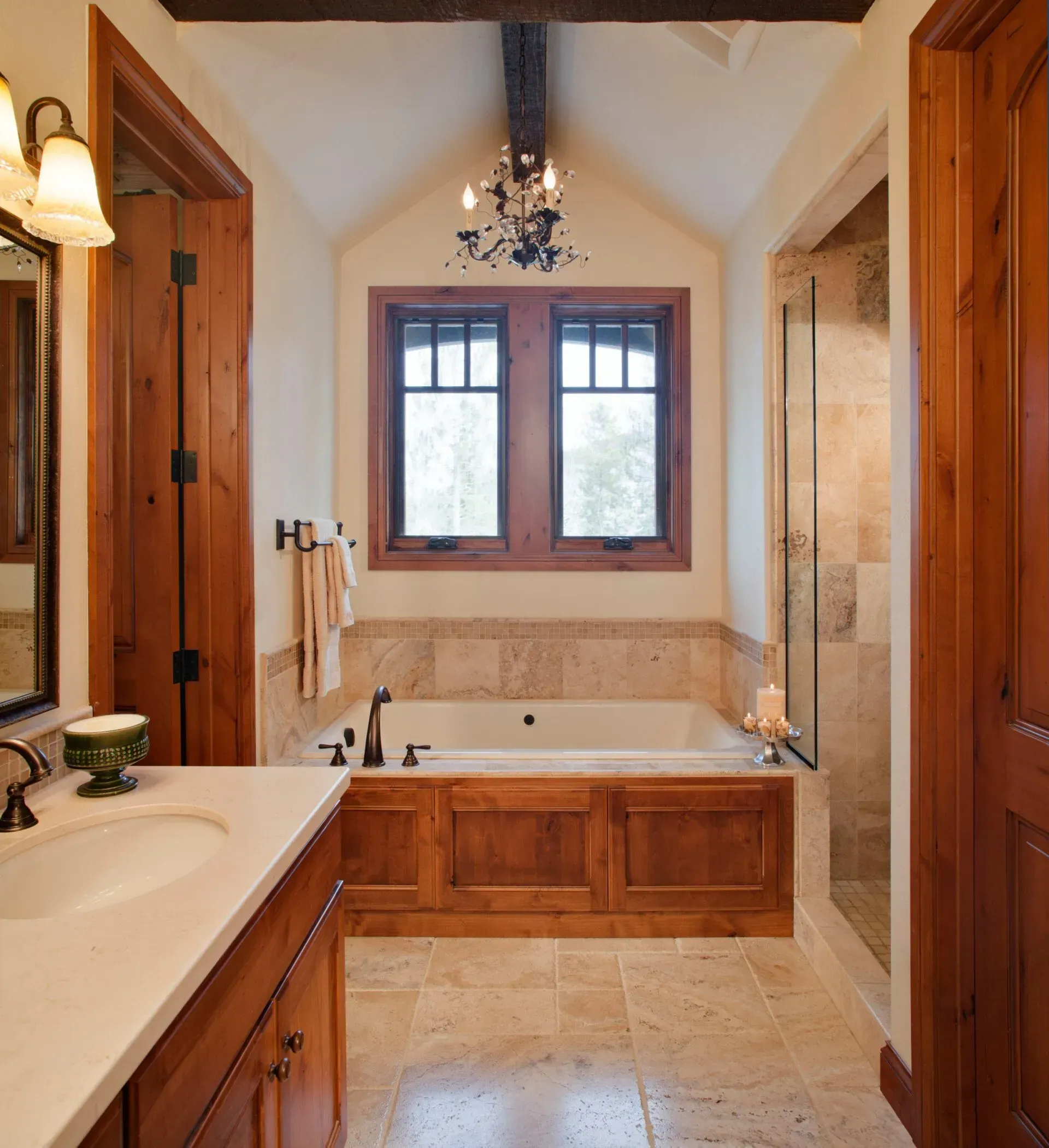 Bathroom with a soaking tub, two windows, wood accents, and a glass shower enclosure.
