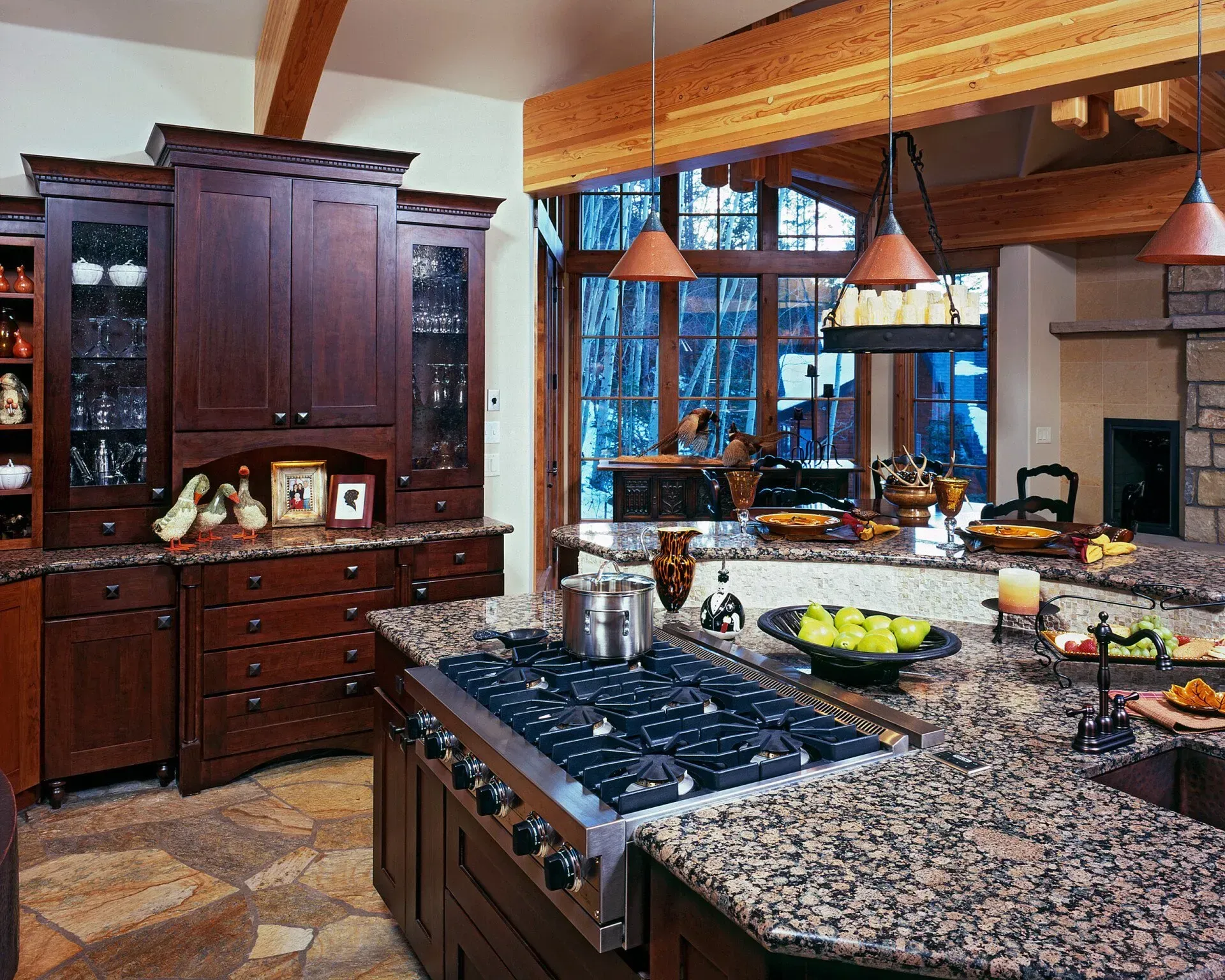Kitchen with dark wood cabinets, granite countertops, and a large stovetop.