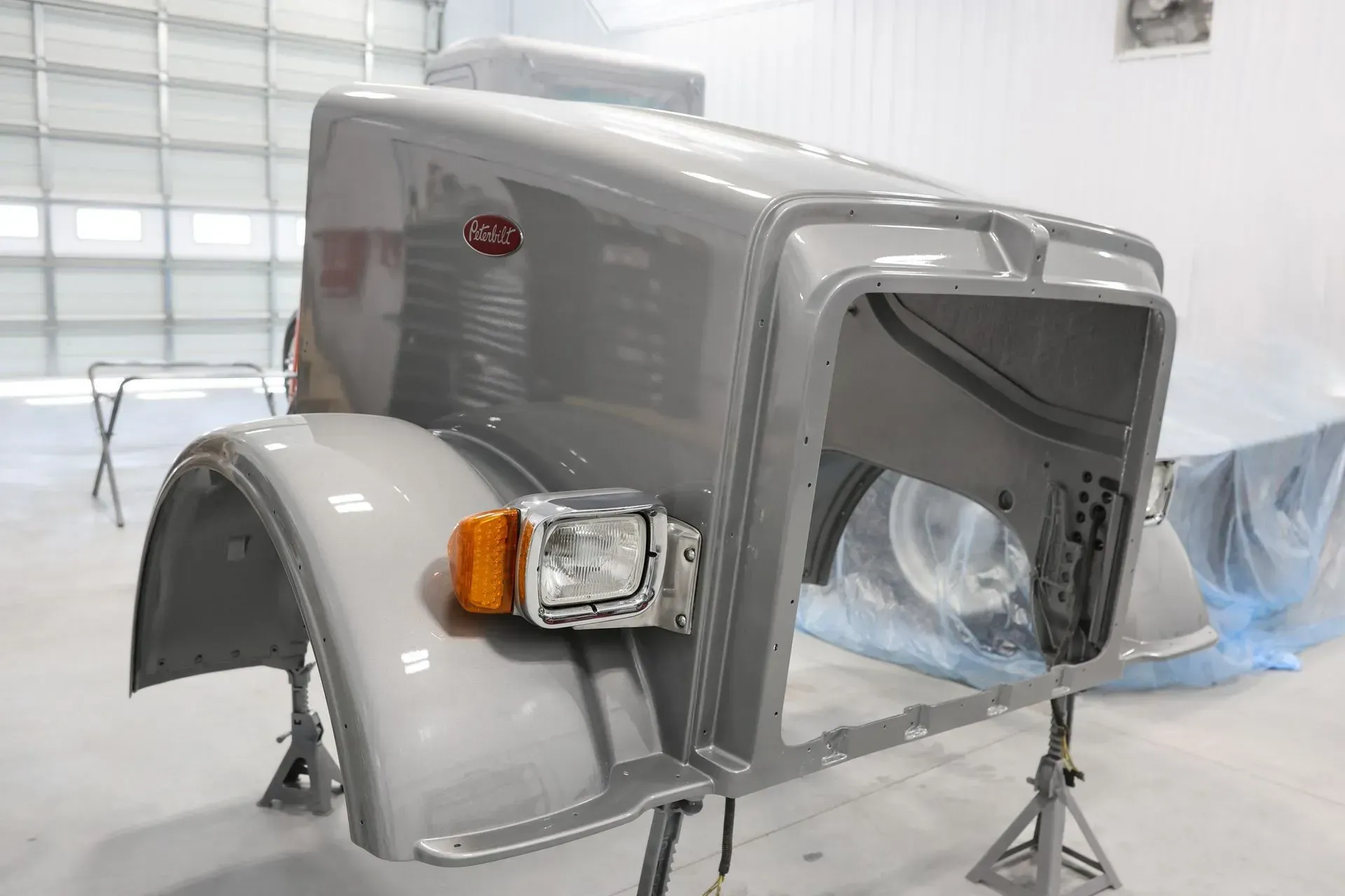 Fiberglass repair work and custom paint job completed on front end of a white semi-truck