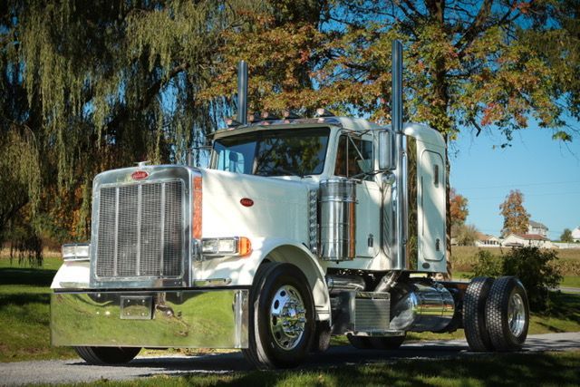 A white semi truck is driving down a highway.