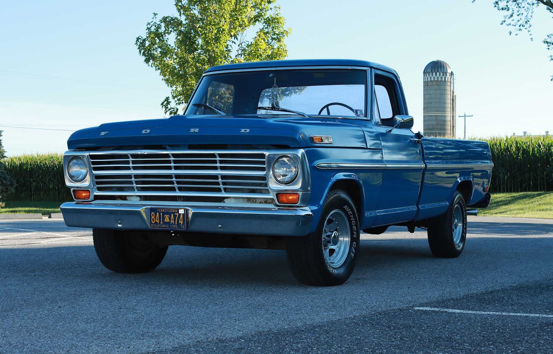 A blue ford truck is parked on the side of the road