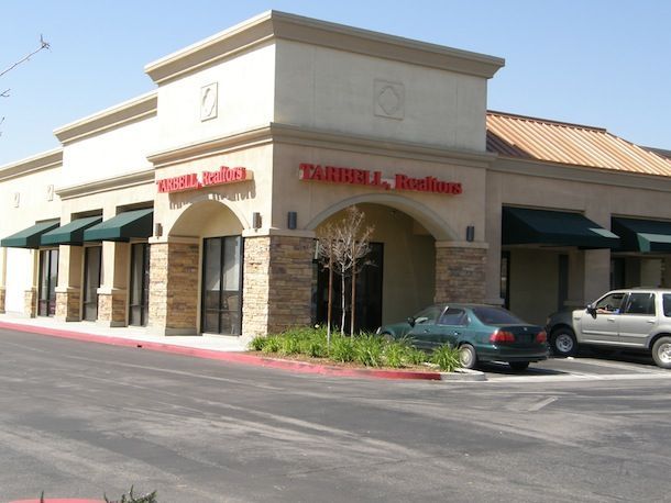 A car is parked in front of a tanner j. studios building