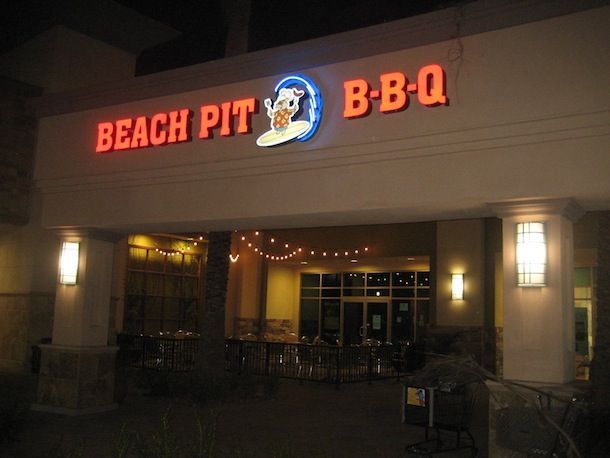 The beach pit bbq restaurant is lit up at night