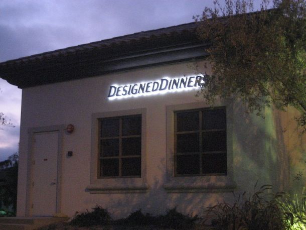A white building with a sign that says designeddinners