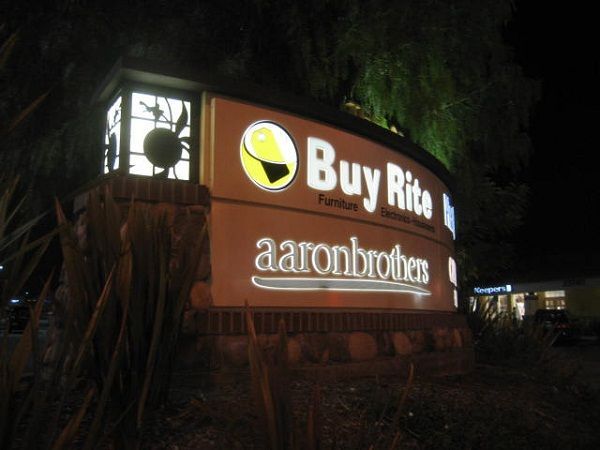 A sign for buy rite aaronbrothers is lit up at night
