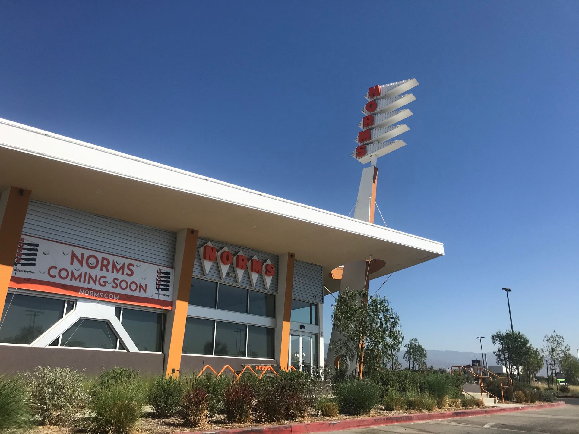 A large building with a sign that says norms coming soon