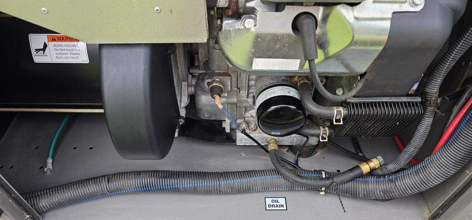 Engine components with a black cylindrical filter, wires, and hoses.