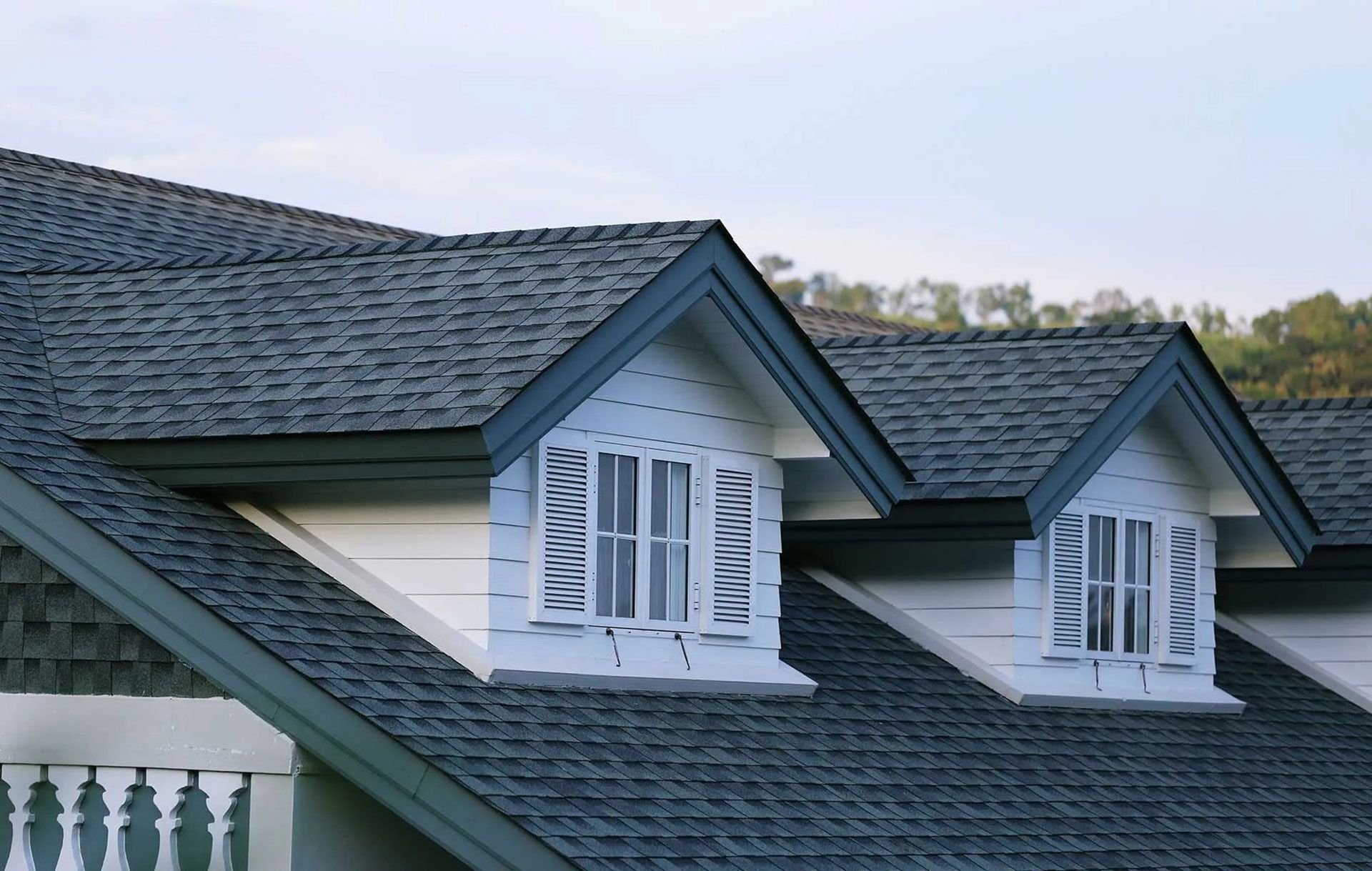 Blue and white dormer windows on a dark shingled roof.