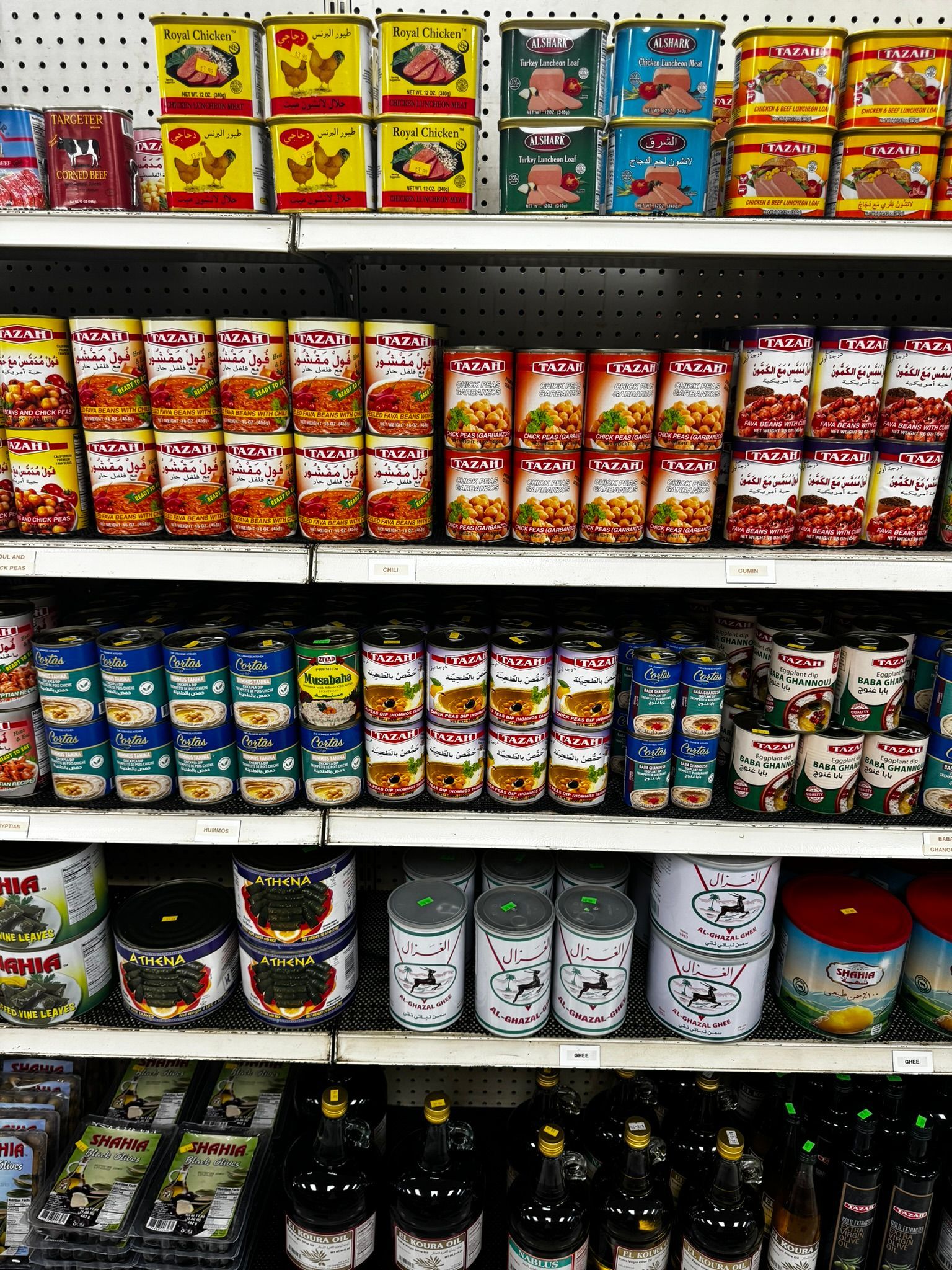 Supermarket shelf stocked with colorful packaged snacks and canned goods
