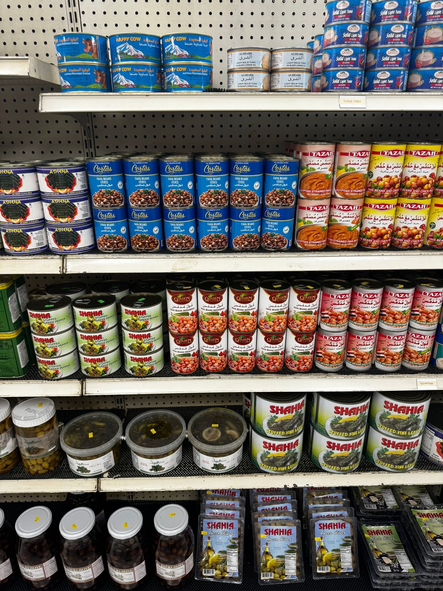 Store shelf stocked with assorted canned soups and packaged snacks in colorful rows.
