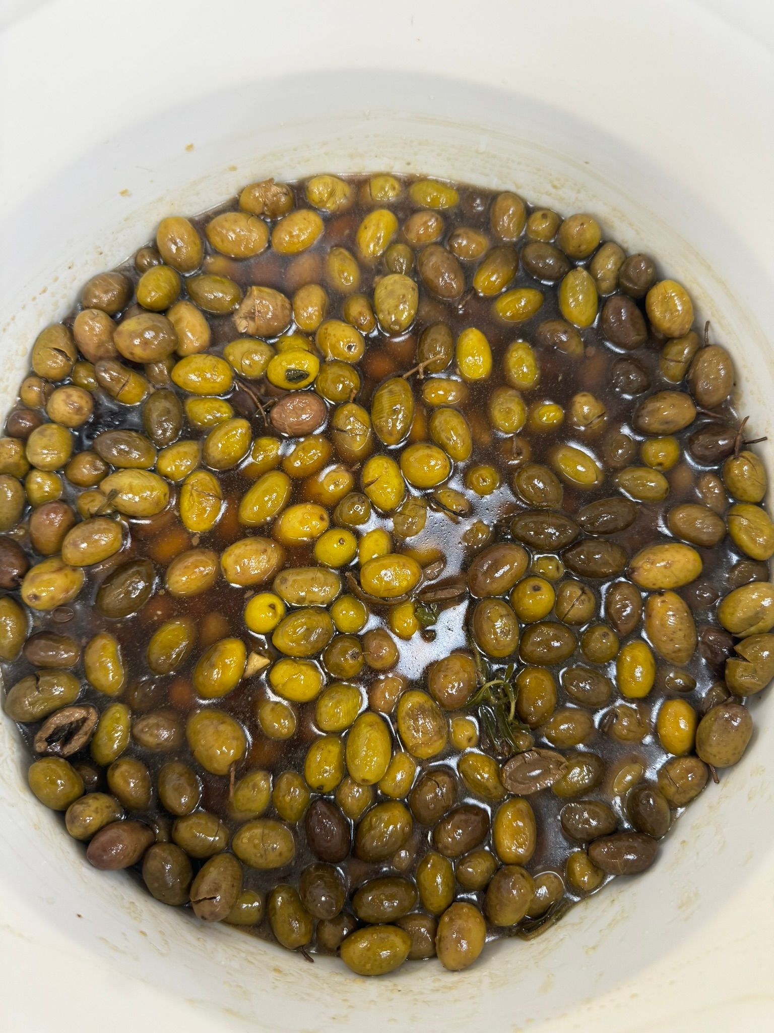 Bowl of small yellow-brown olives or beans soaking in water