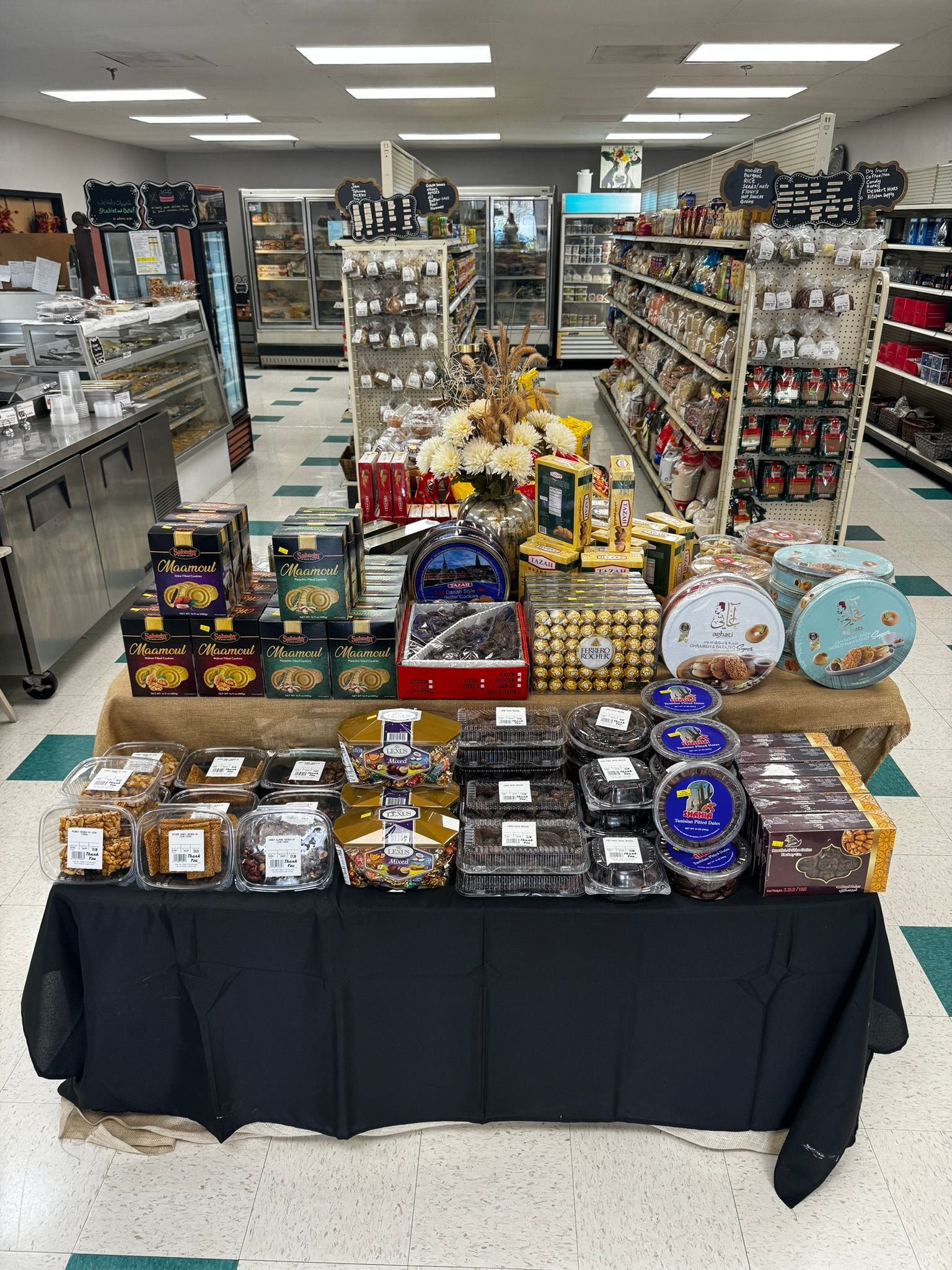 Gift display table in a store aisle with assorted packaged treats and decorative items