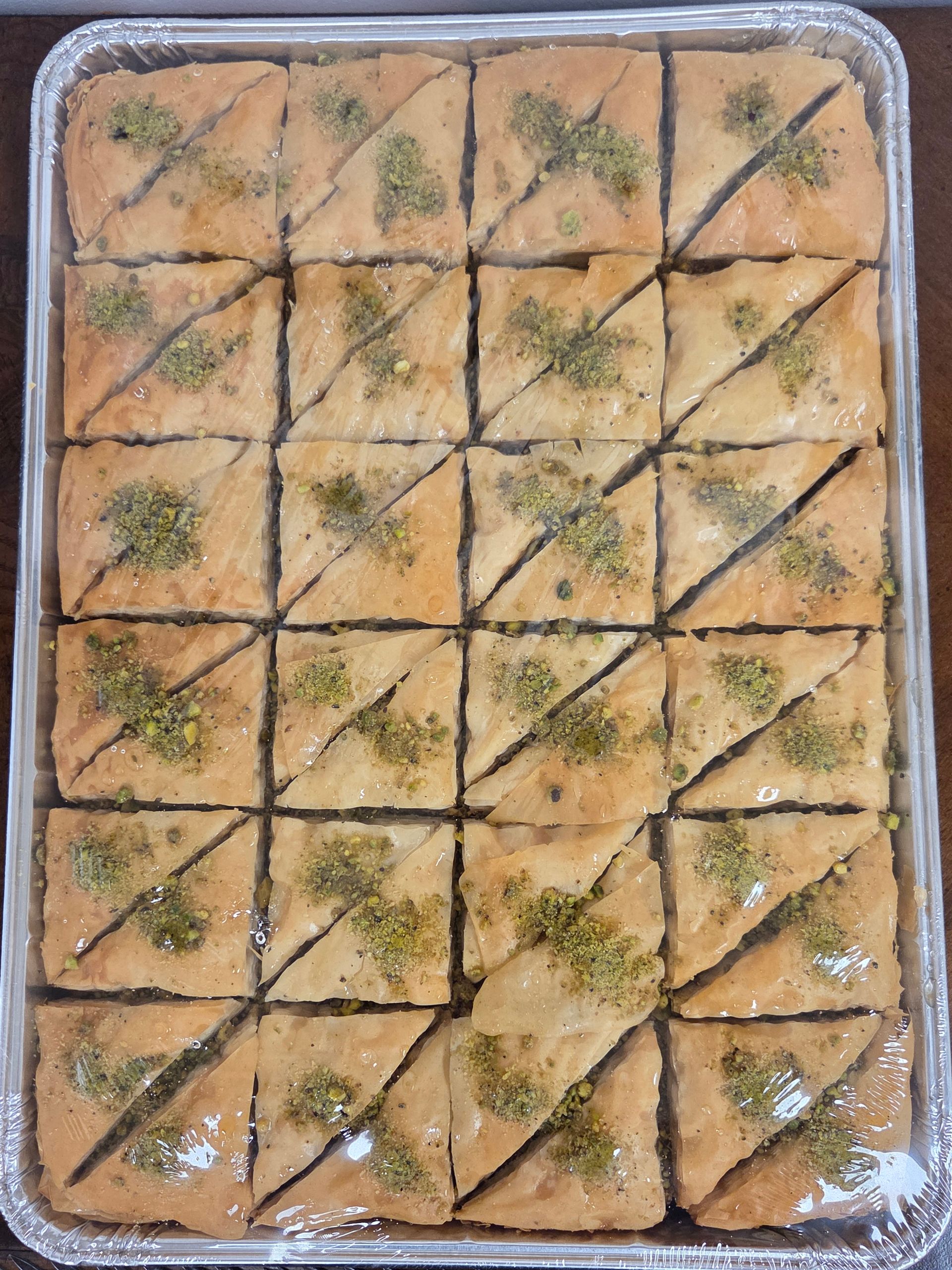 Tray of golden baked pastry squares topped with herbs and diagonal cuts