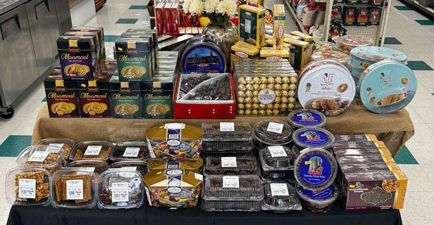 Market stall displaying assorted packaged sweets and snacks on stacked wooden boxes.