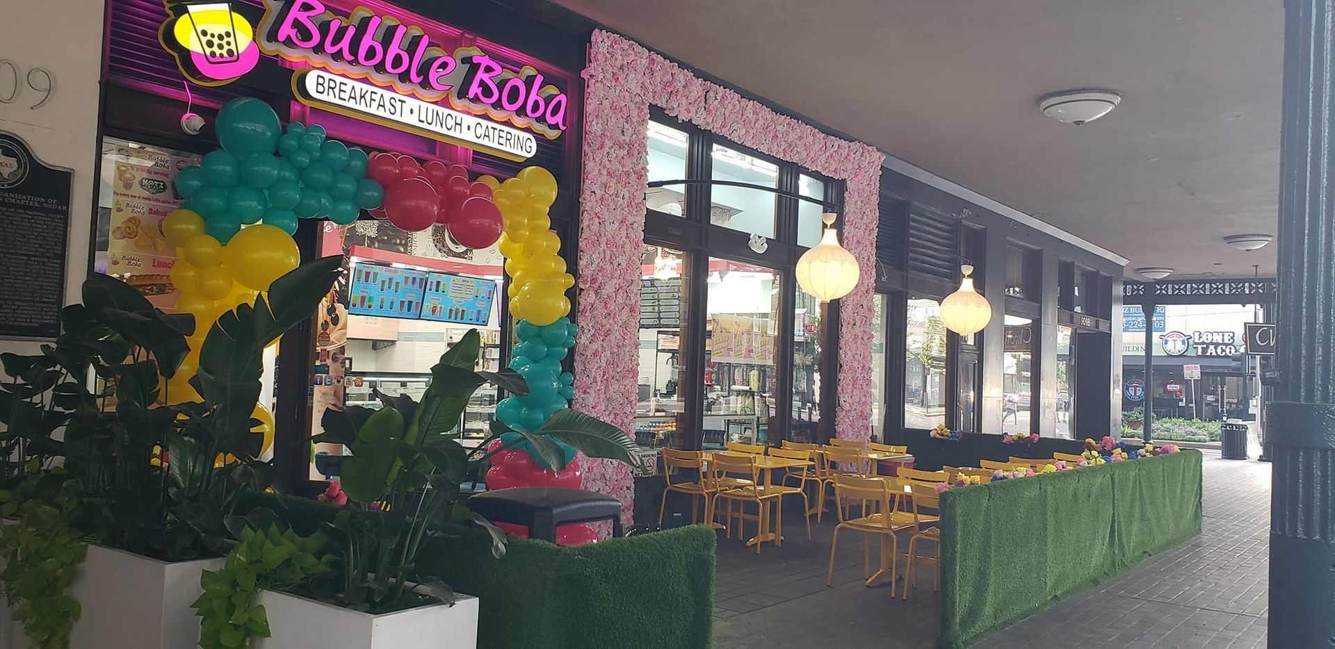 A restaurant with a lot of balloons on the front of it.