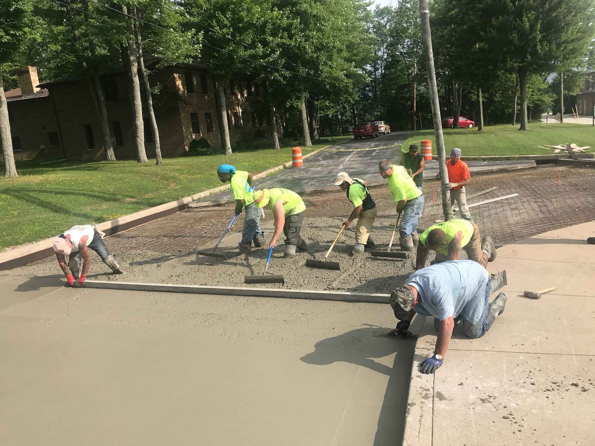 A group of construction workers are working on a sidewalk.