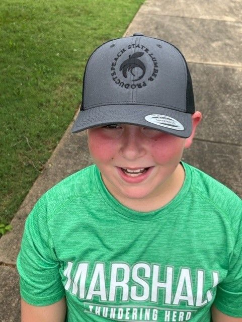 Kid in green shirt wearing a hat.