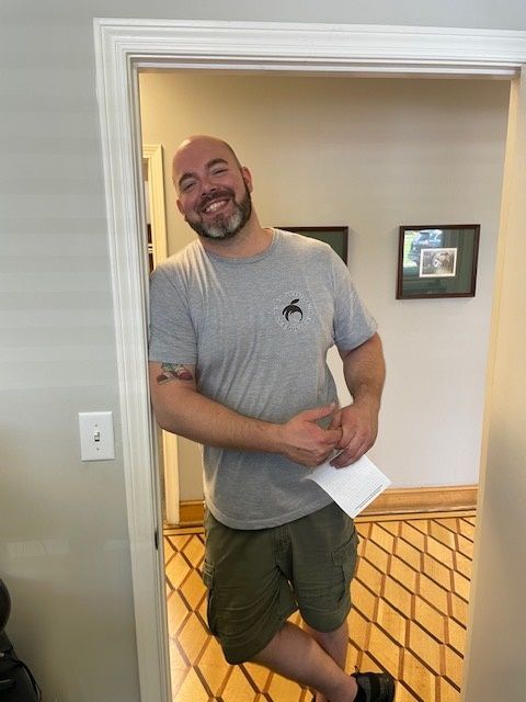 A man standing in a doorway holding a piece of paper