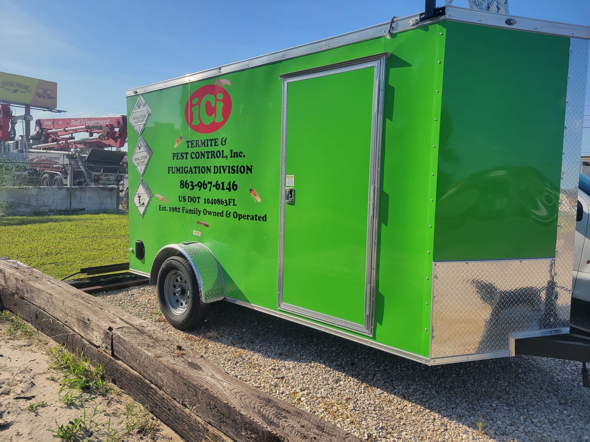 A green trailer is parked on the side of the road.