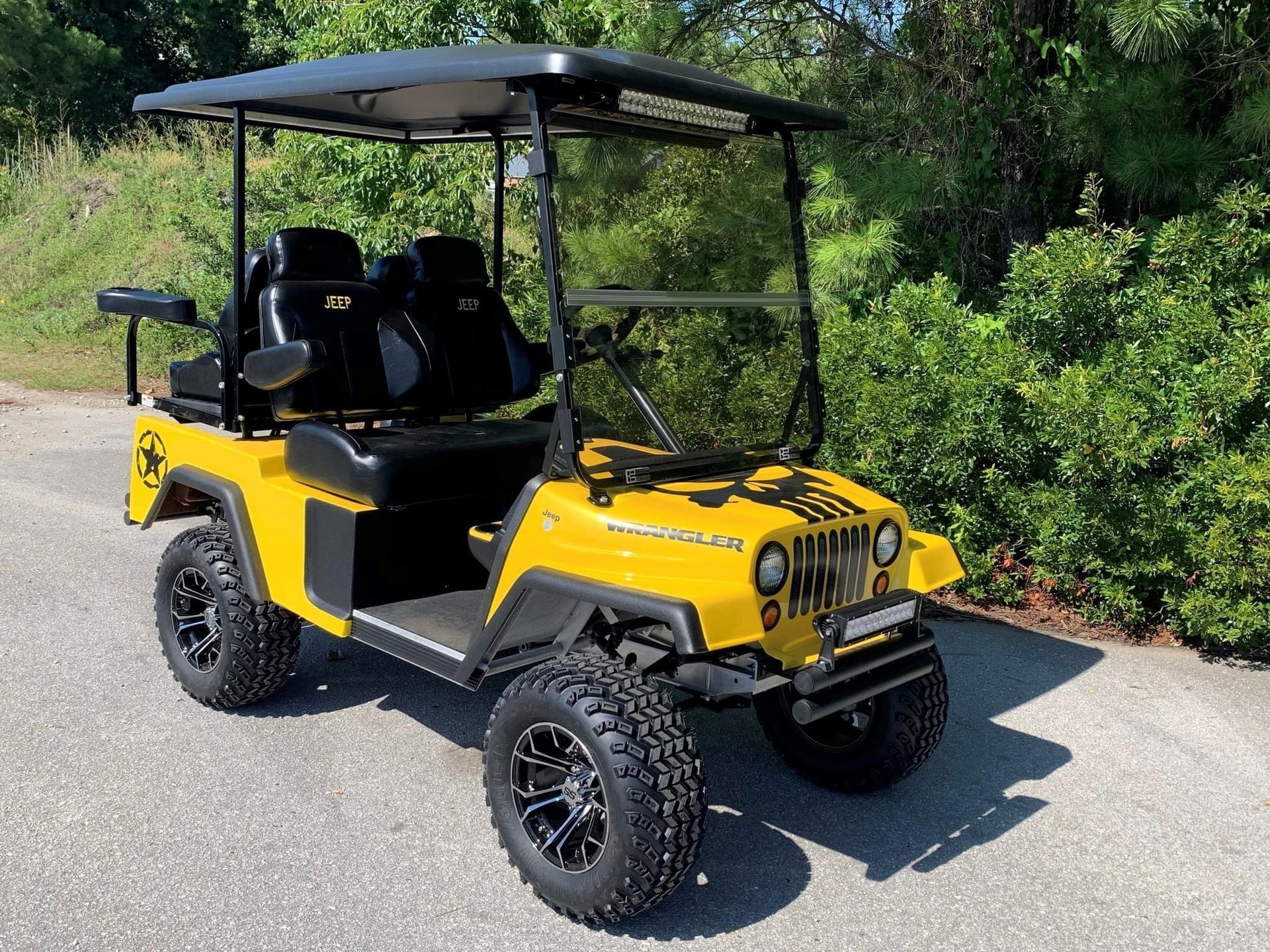 A yellow golf cart is parked on the side of the road.