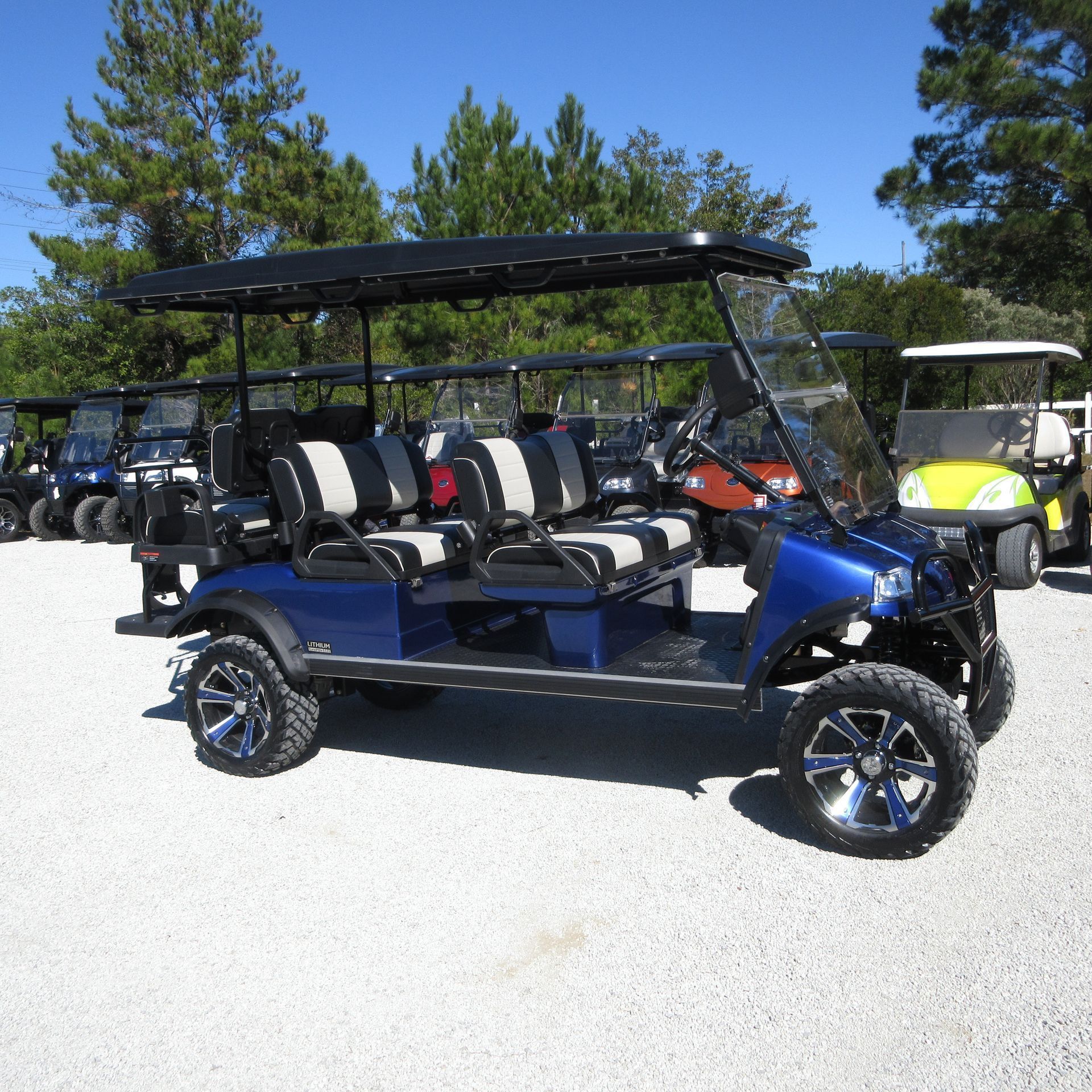 A blue golf cart is parked in a gravel lot