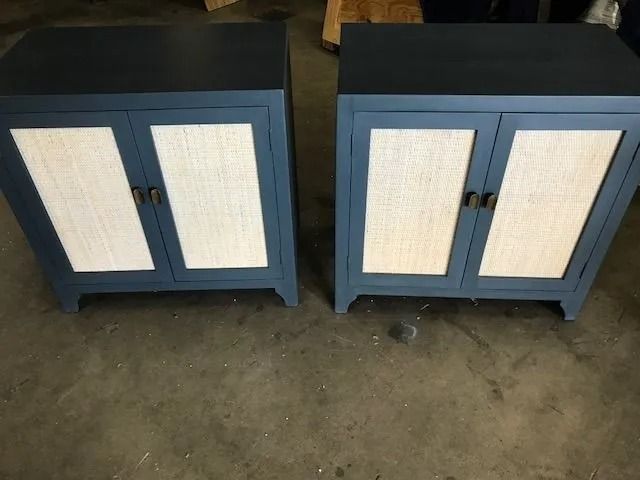 Two blue cabinet doors with white woven panels on a concrete floor