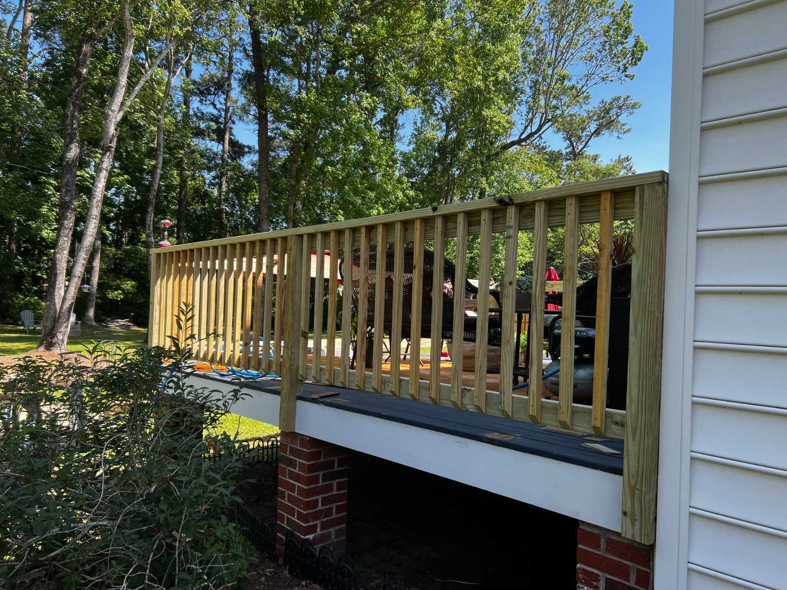 A wooden deck is attached to the side of a house.