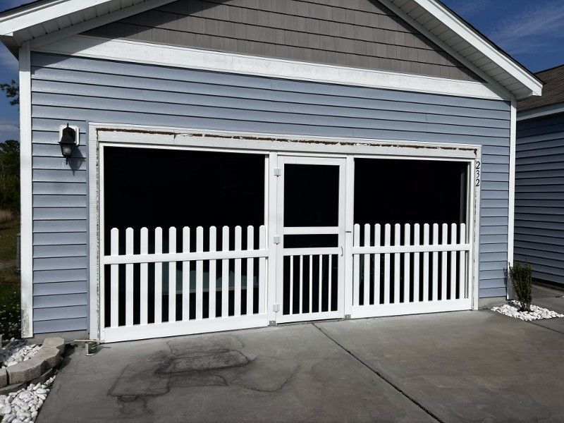 A blue house with a screened in garage door