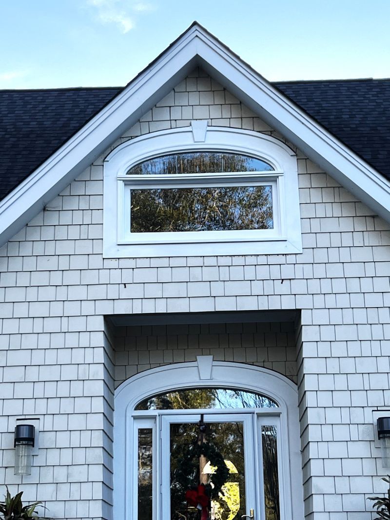 A white brick house with a wreath on the door