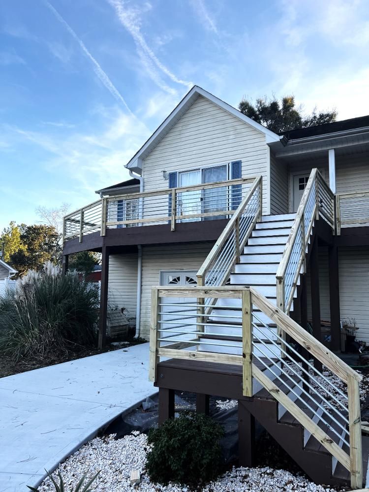 A house with a deck and stairs leading up to it.
