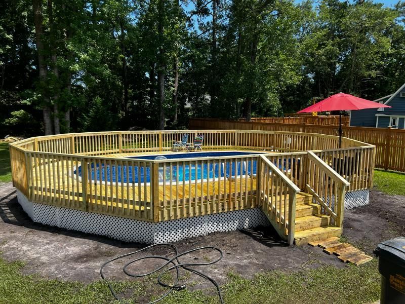 A large swimming pool with a wooden deck around it