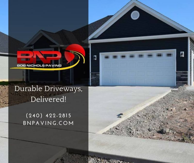 A house with a newly poured concrete driveway featuring an overlay with the B&N Paving company logo, phone, and website.