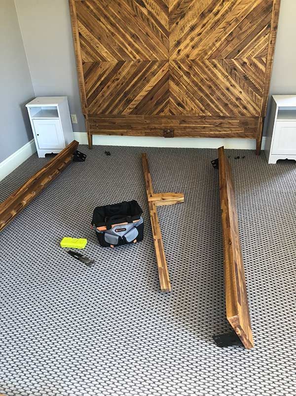 A wooden headboard is being built in a bedroom.