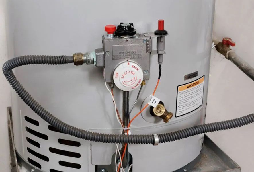 Gas water heater with temperature controls and gas line attached.