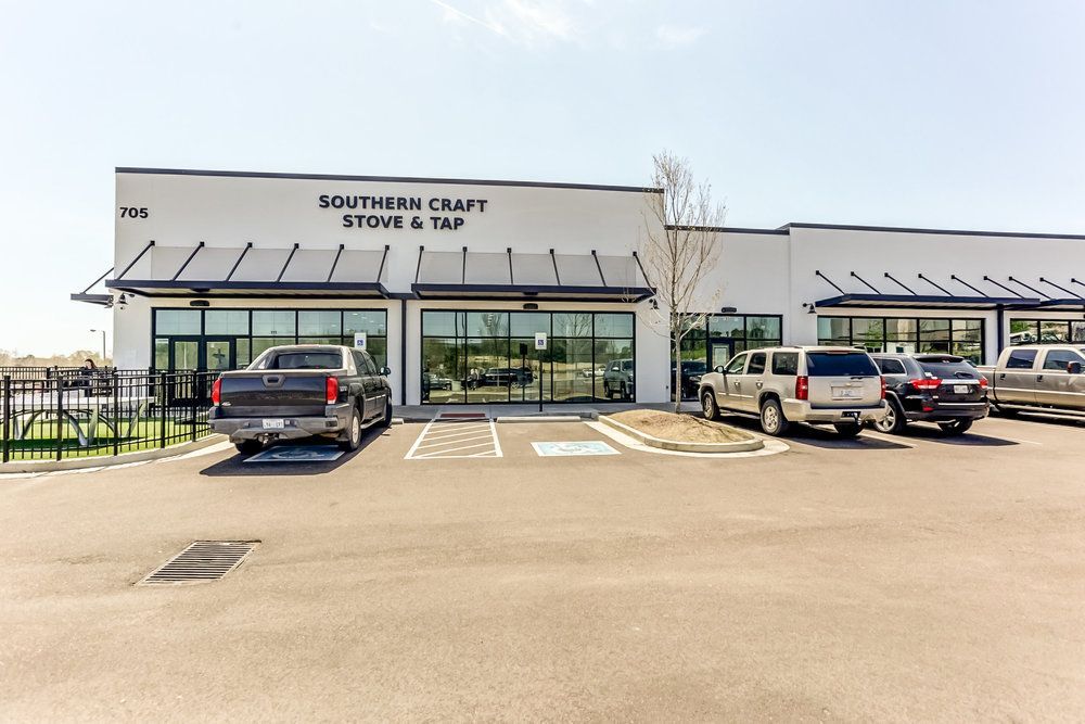 A group of cars are parked in front of a building.
