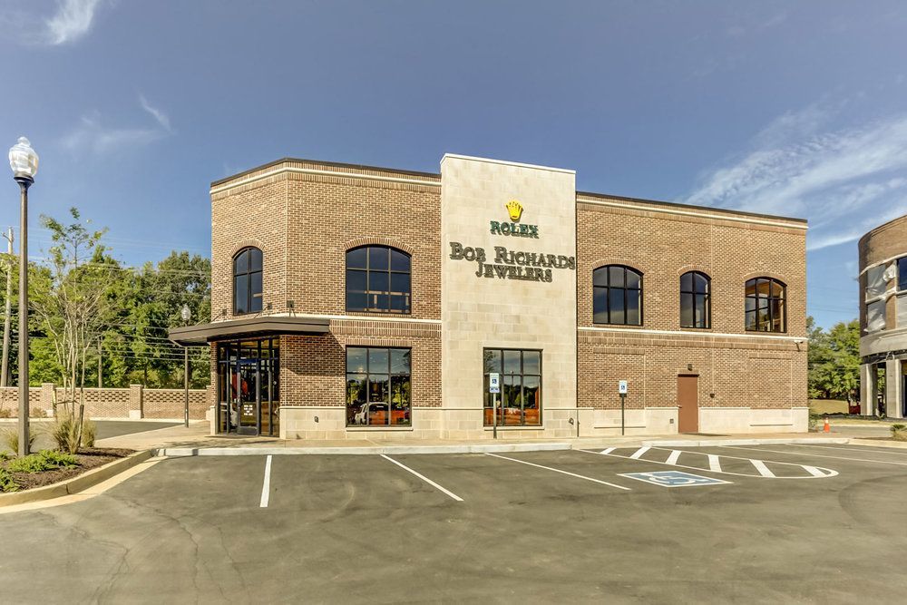 A large brick building with a parking lot in front of it.