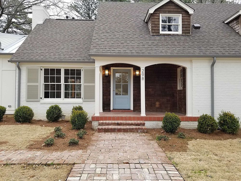 Exterior (After) - White house with blue door and brick walkway.
