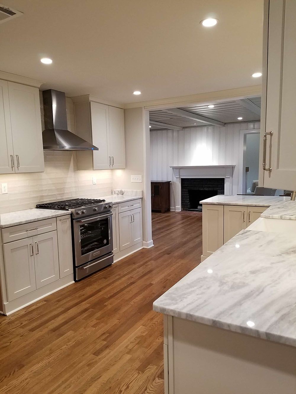 Kitchen (In Progress) - Modern kitchen with white cabinets, stainless steel appliances, marble countertops, and hardwood floors.