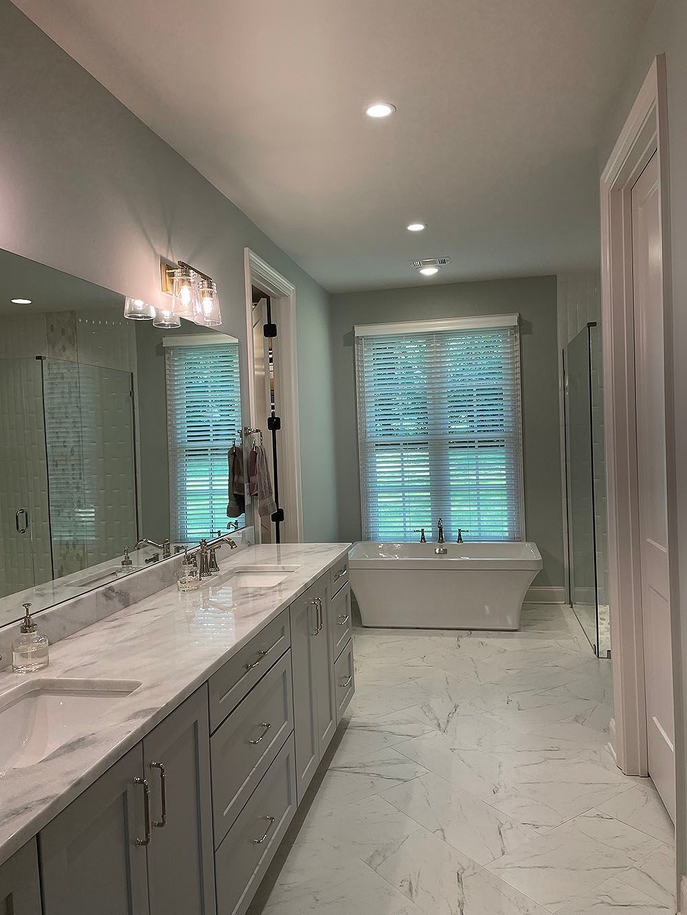 Master Bath 3 - Spacious master bathroom with a double vanity, soaking tub, and large window with a blind.