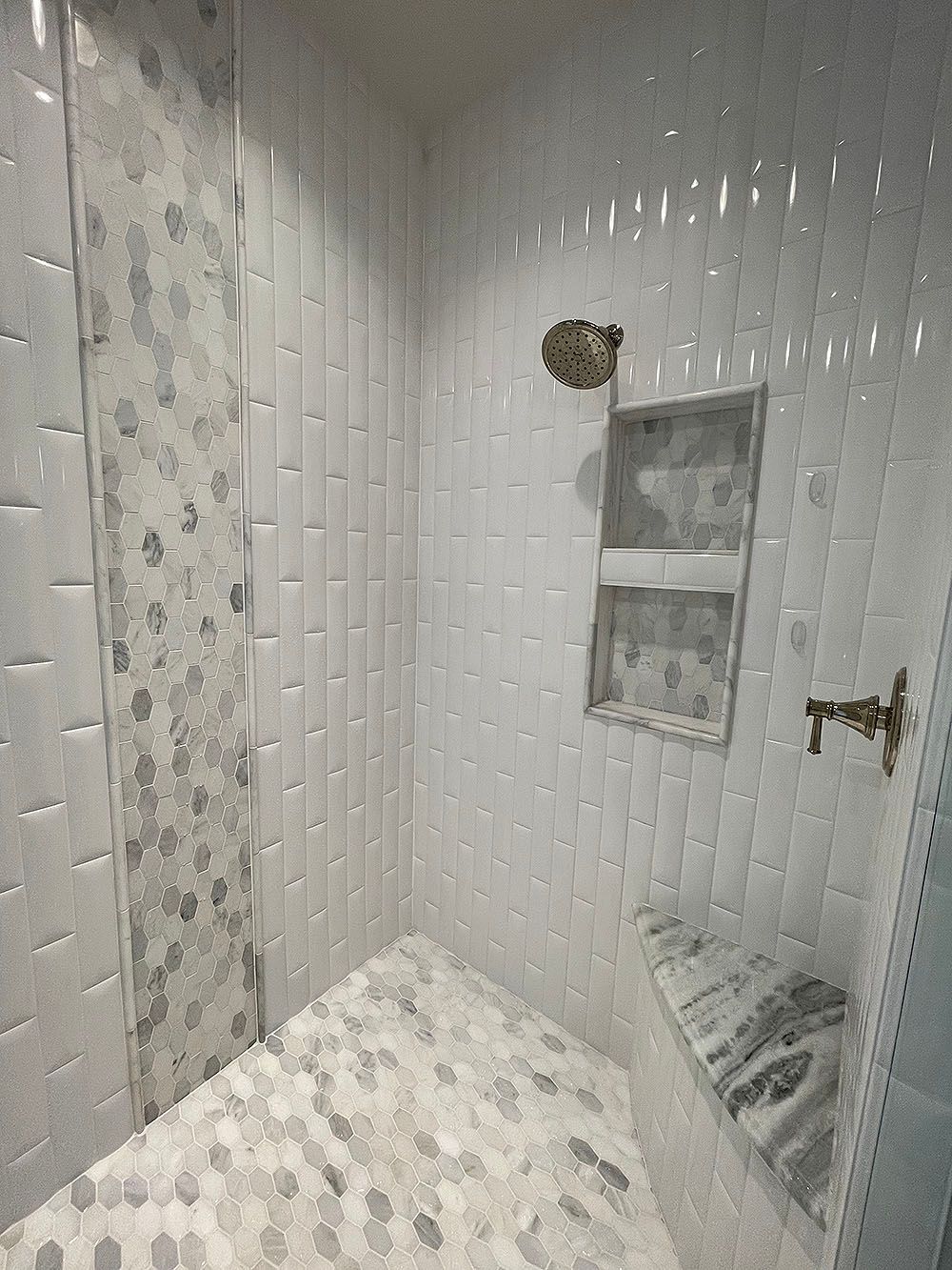 Master Bath 5 - White tiled shower with mosaic accent, built-in shelf, and gold-colored faucet.